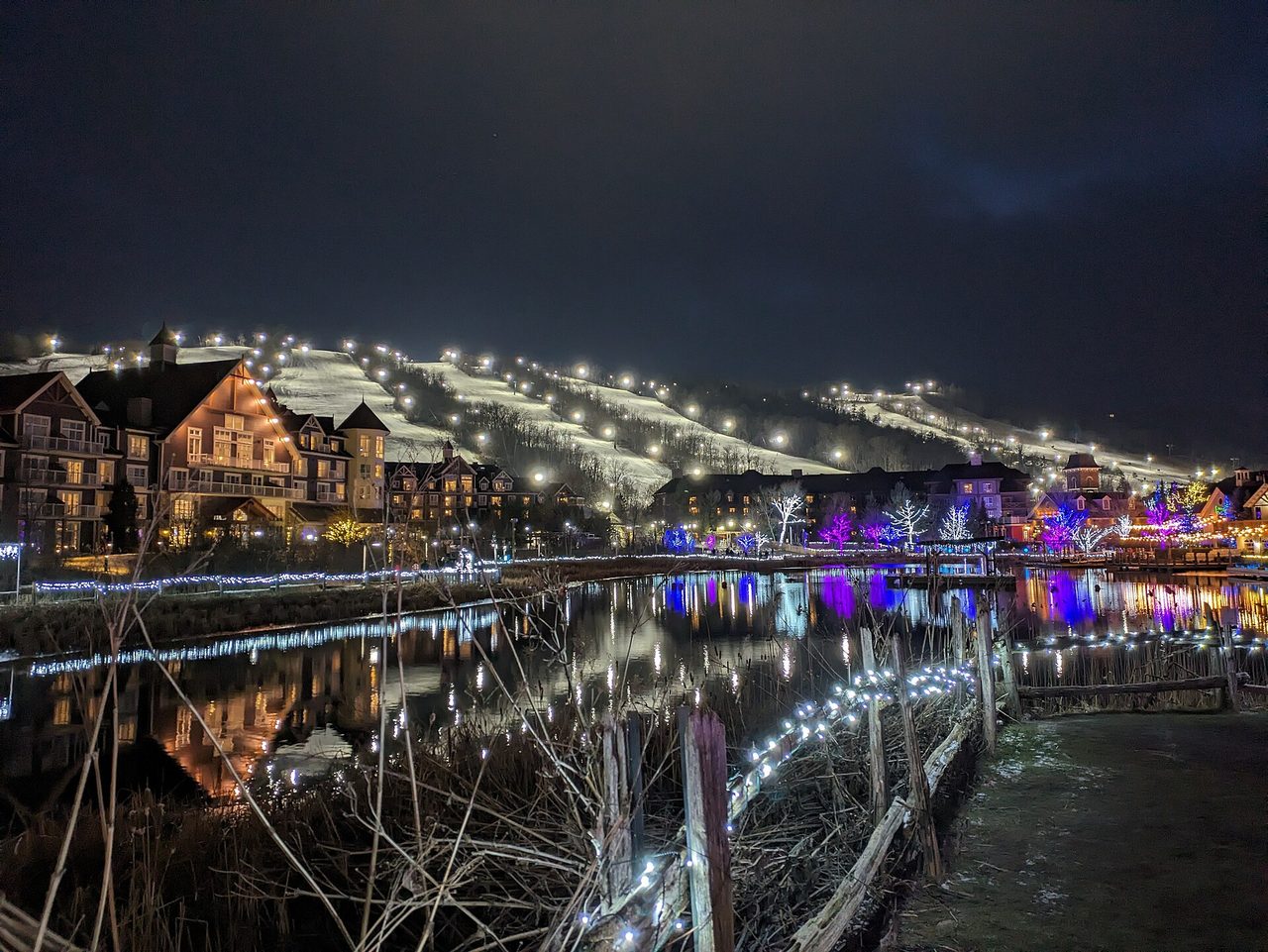 The resort village pond and buildings lit up at night in winter