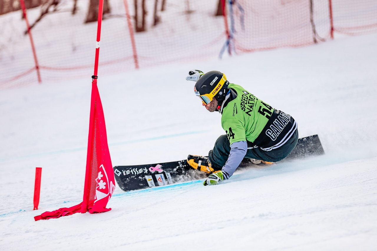 A ski racer carving through a gate on a groomed race course